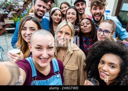 Große Selfie-Gruppe, viele Menschen um eine Frau, die einen großen Selfy einer multirassischen Gruppe, Studenten, die Spaß haben, große Party, Menschen aus verschiedenen Teil o Stockfoto