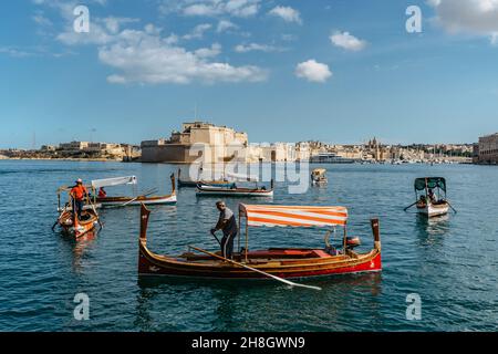 Valletta, Malta - Oktober 18,2021. Alte hölzerne lokale Fährschiffe von Valletta nach Birgu Vittoriosa. Traditionelles maltesisches Wassertaxi mit Schiffen Stockfoto