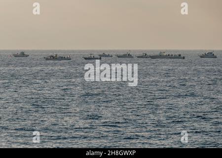 Eine Gruppe von Fischerbooten Reihen sich am Horizont vor der Küste von Livorno, Italien, an Stockfoto