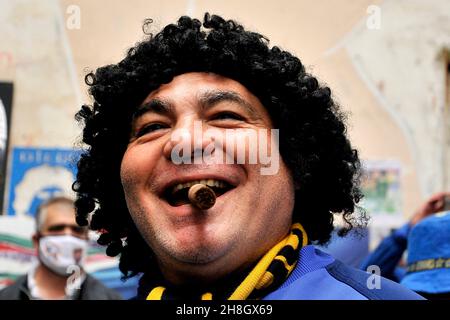 Ein Boca Juniors Fan mit einer Zigarre im Mund feiert auf dem Wandbild von Diego Armando Maradona im Spanischen Viertel, zum Jahrestag der Tannen Stockfoto