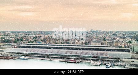 Luftaufnahme im Winter mit Schneefall von Amsterdam mit dem Hauptbahnhof vor Stockfoto