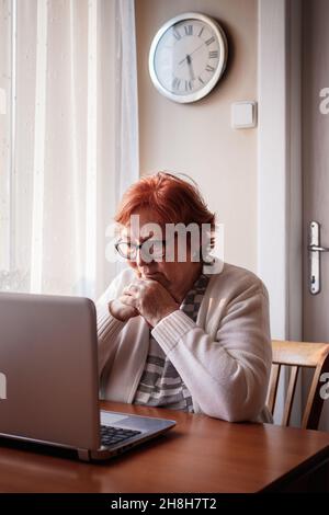 Ältere Frau während eines Videoanrufs von zu Hause aus. Alte Menschen nutzen Laptop und Internet für die Kommunikation Stockfoto