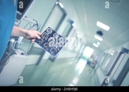 Der Arzt untersucht das MRT-Bild des Patienten im Krankenhausflur. Stockfoto