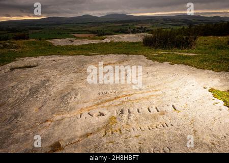 Moderne Graffiti auf neolithischer Felskunst auf Chatton Park Hill in Northumberland, Großbritannien Stockfoto