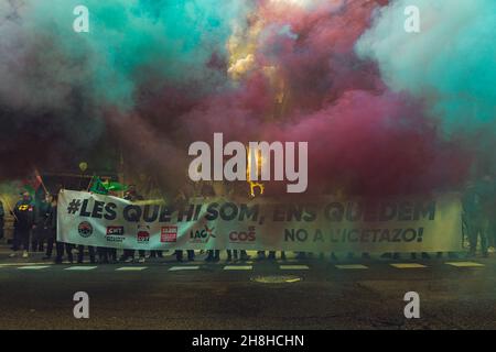 Barcelona, Spanien. 30th. November 2021. Mitglieder des öffentlichen Sektors, die hinter ihrem Banner für mehr Rechte, Gleichheit und den Missbrauch von Zeitarbeit protestieren, sind mit farbigem Rauch überzogen.Quelle: Matthias Oesterle/Alamy Live News Stockfoto