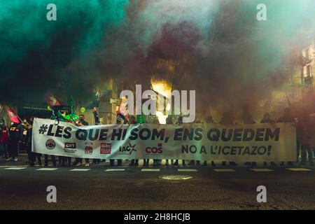 Barcelona, Spanien. 30th. November 2021. Mitglieder des öffentlichen Sektors, die hinter ihrem Banner für mehr Rechte, Gleichheit und den Missbrauch von Zeitarbeit protestieren, sind mit farbigem Rauch überzogen.Quelle: Matthias Oesterle/Alamy Live News Stockfoto