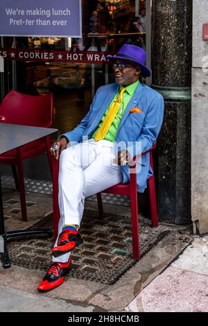 Ein gut gekleideter Mann, der vor Einem Café in der Marylebone High Street, London, Großbritannien, sitzt. Stockfoto
