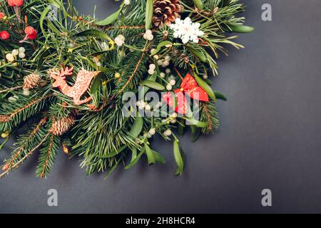 Weihnachts- und Neujahrskranz aus Tanne, Kiefer, Mistelzweigen, Zapfen mit roten Ornamenten. Stockfoto