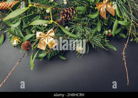 Weihnachts- und Neujahrsdekoration aus Tanne, Kiefer, Mistelzweigen, Zapfen mit goldenen Ornamenten, Spielzeug. Platz Stockfoto