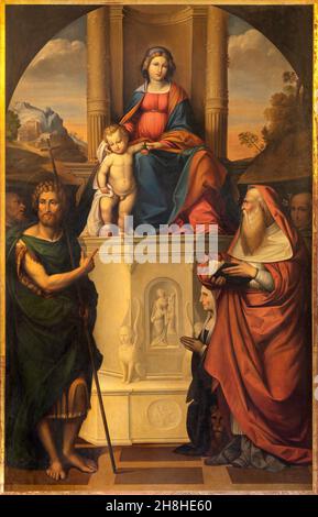 FERRARA, ITALIEN - 9. NOVEMBER 2021: Das Gemälde der Madonna mit Johannes dem Täufer, Hieronymus und anderen in der Kirche Chiesa di San Francesco. Stockfoto