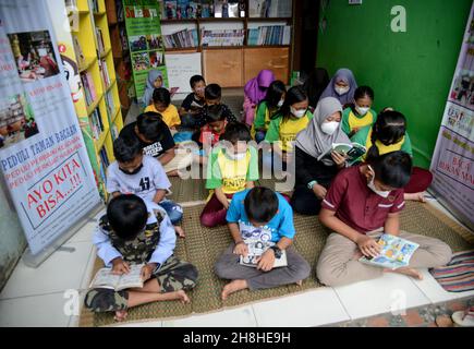 Bogor, Indonesien. 29th. November 2021. Eine Gruppe von Kindern, die am 29. November 2021 in einer Gemeinschaftsbibliothek am Fuße des Mount Salak im Dorf Sukaluyu in Bogor, West-Java, Indonesien, Bücher lesen. (Foto von Adriana Adie/INA Photo Agency/Sipa USA) Quelle: SIPA USA/Alamy Live News Stockfoto