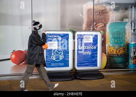 Taplow, Buckinghamshire, Großbritannien. 30th. November 2021. Vorübergehendes Tragen einer Gesichtsbedeckung im Geschäft ist Pflicht-Schilder außerhalb Tesco Supermarkt. Nachdem in England eine Reihe von aufgezeichneten Fällen der neuen Covid-19-Variante Omicron identifiziert worden sind, ist es ab heute wieder obligatorisch, Gesichtsmasken oder Gesichtsbezüge in Geschäften in England zu tragen, sofern keine medizinische Ausnahme besteht. Quelle: Maureen McLean/Alamy Live News Stockfoto