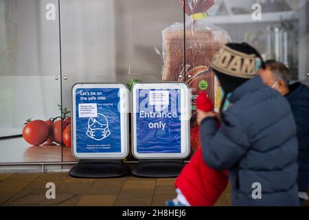 Taplow, Buckinghamshire, Großbritannien. 30th. November 2021. Vorübergehendes Tragen einer Gesichtsbedeckung im Geschäft ist Pflicht-Schilder außerhalb Tesco Supermarkt. Nachdem in England eine Reihe von aufgezeichneten Fällen der neuen Covid-19-Variante Omicron identifiziert worden sind, ist es ab heute wieder obligatorisch, Gesichtsmasken oder Gesichtsbezüge in Geschäften in England zu tragen, sofern keine medizinische Ausnahme besteht. Quelle: Maureen McLean/Alamy Live News Stockfoto