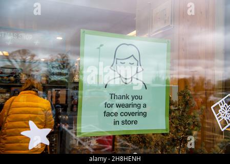 Taplow, Buckinghamshire, Großbritannien. 30th. November 2021. Ein Gesichtsmaskenschild in einem Schaufenster. Nachdem in England eine Reihe von aufgezeichneten Fällen der neuen Covid-19-Variante Omicron identifiziert worden sind, ist es ab heute wieder obligatorisch, Gesichtsmasken oder Gesichtsbezüge in Geschäften in England zu tragen, sofern keine medizinische Ausnahme besteht. Quelle: Maureen McLean/Alamy Live News Stockfoto