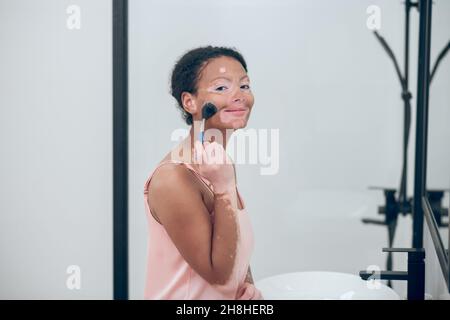 Eine hübsche, lockige Frau, die macht und erfreut aussieht Stockfoto