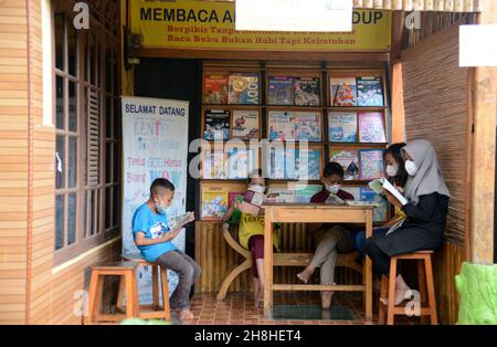 Bogor, Indonesien. 29th. November 2021. Eine Gruppe von Kindern, die am 29. November 2021 in einer Gemeinschaftsbibliothek am Fuße des Mount Salak im Dorf Sukaluyu in Bogor, West-Java, Indonesien, Bücher lesen. (Foto von Adriana Adie/INA Photo Agency/Sipa USA) Quelle: SIPA USA/Alamy Live News Stockfoto