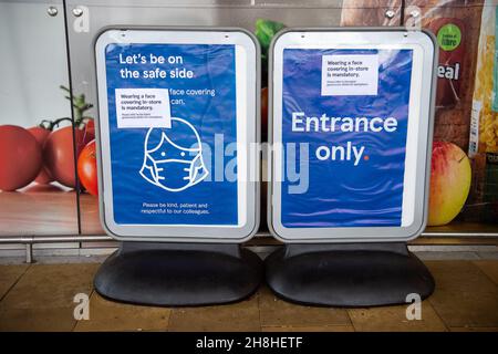 Taplow, Buckinghamshire, Großbritannien. 30th. November 2021. Vorübergehendes Tragen einer Gesichtsbedeckung im Geschäft ist Pflicht-Schilder außerhalb Tesco Supermarkt. Nachdem in England eine Reihe von aufgezeichneten Fällen der neuen Covid-19-Variante Omicron identifiziert worden sind, ist es ab heute wieder obligatorisch, Gesichtsmasken oder Gesichtsbezüge in Geschäften in England zu tragen, sofern keine medizinische Ausnahme besteht. Quelle: Maureen McLean/Alamy Live News Stockfoto