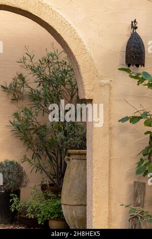 Lampe im arabischen Stil an der Wand eines typischen Gebäudes im mittelöstlichen Architekturstil mit Bögen und touristischen Dekorationen. Hochwertige Fotos Stockfoto