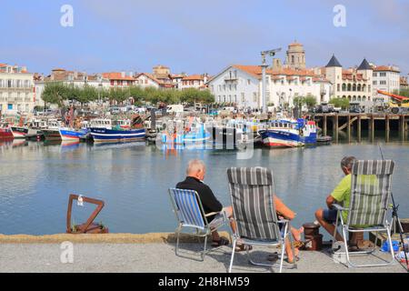 Frankreich, Pyrenäen Atlantiques, Baskenland, Saint Jean de Luz, Hobbyfischer im Fischereihafen mit dem Ort Louis XIV im Hintergrund links Stockfoto