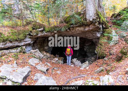 Frankreich, Savoie, Massiv und Bauges regionaler Naturpark, Aillon-le-Jeune, Sentier des Tannes und Gletscher, Wanderer vor dem Eingang zu einer der vielen Höhlen auf dem Hochplateau (MR ja) Stockfoto