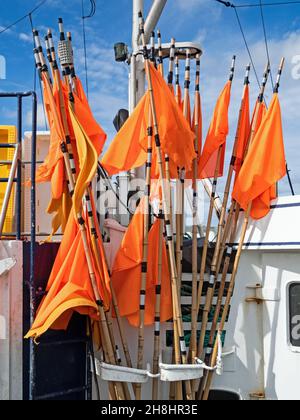 Orangefarbene Flaggen kennzeichnen Fischernetze an Bord eines Fischerbootes im Hafen von Hanstholm, Dänemark Stockfoto