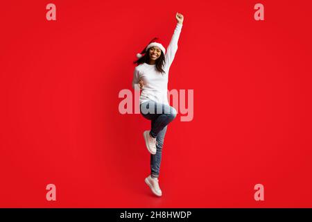 Fröhliche afroamerikanische junge Frau, die Erfolg feiert Stockfoto