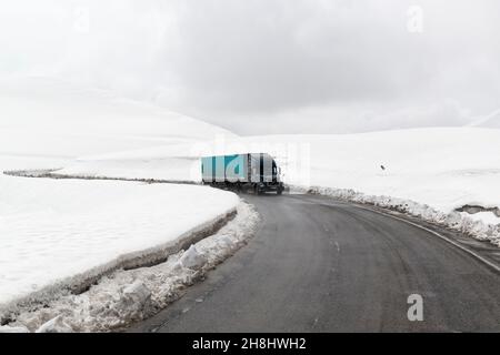 Schwere russische LKW auf dem Jvari Pass, Teil der georgischen Militärstraße nach Schneefall. Region Mzcheta-Mtianeti, Georgien, Kaukasus Stockfoto