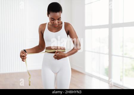 Schwarze Frau, Die Die Taille Mit Klebeband Misst. Diät Abnehmen Konzept Stockfoto