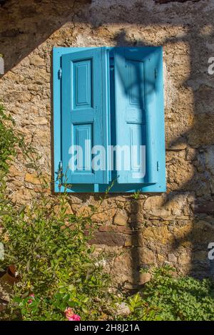 Ein blaues Fenster in einem historischen Gebäude im Alpendorf Sauris di Sopra, Provinz Udine, Friaul-Julisch Venetien, Italien. Ende September Stockfoto