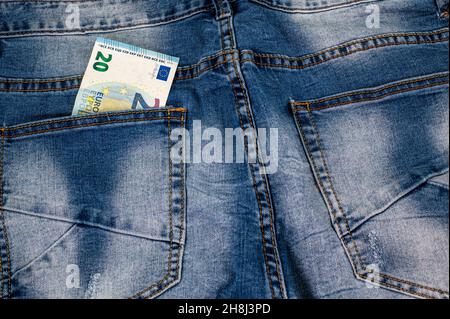 Nahaufnahme von 20 Euro, die aus der Tasche der blauen Jeans kommen Stockfoto