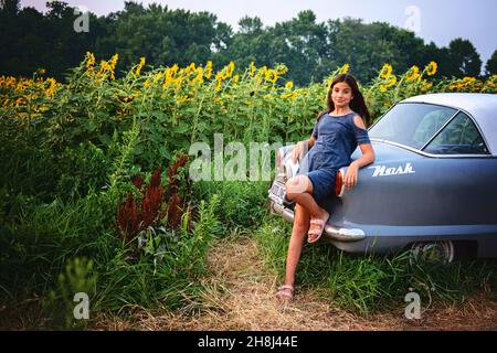 Glückliches Tween Mädchen in einem Sonnenblumenfeld. Stockfoto