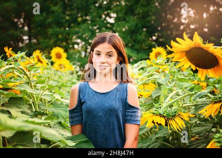 Glückliches Tween Mädchen in einem Sonnenblumenfeld. Stockfoto