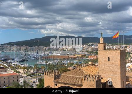 Blick über Palma, Mallorca und den Hafen mit Palast und spanischer Flagge vor dem Hotel, wolkiger Tag Stockfoto