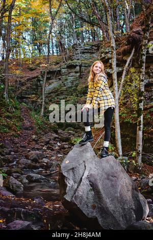 Rothaarige Tween Girl Wandern in den Herbstwäldern. Stockfoto