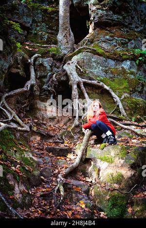 Rothaarige Tween Girl Wandern in den Herbstwäldern. Stockfoto