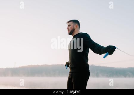 Mann, der morgens Sport macht. Fokussiertes männliches Springseil. Stockfoto