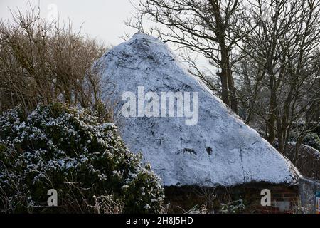 Das Strohdach im Pagham Harbour Nature Reserve wurde im November 2021 mit einem Staubstauben von Schnee bedeckt gesehen. Stockfoto