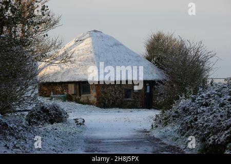 Reetdach einer Hütte im Pagham Harbour Nature Reserve, gesehen bedeckt mit einem Stauben von Schnee im November 2021. Stockfoto