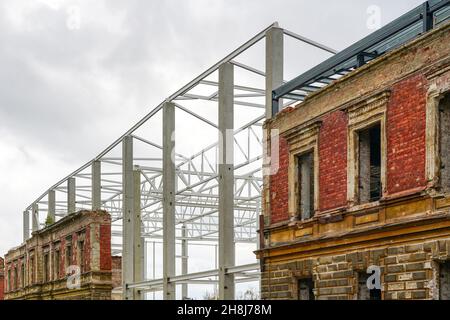 Integration der Fassade des alten Backsteingebäudes in ein neues, modernes Industriegehäuse aus Metall Stockfoto