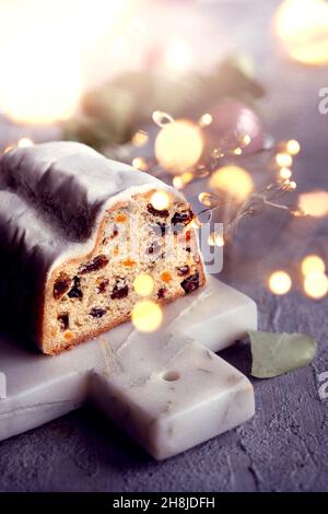 Weihnachtsstollen auf blaugrünem festlichem Hintergrund mit Girlande, Weihnachtsbeleuchtung. Stockfoto