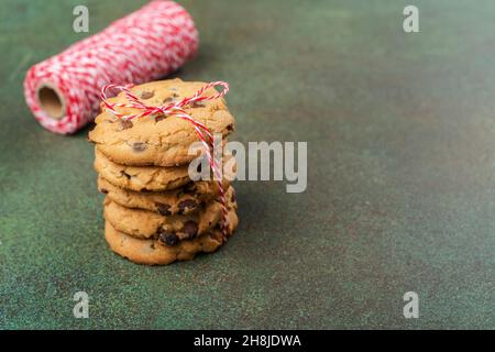 Nationaler Cookie-Tag, 4th. Dezember Hintergrund. Die Hand der Frau hält einen Stapel Schokoladenchips knusprige Kekse. Speicherplatz kopieren Stockfoto