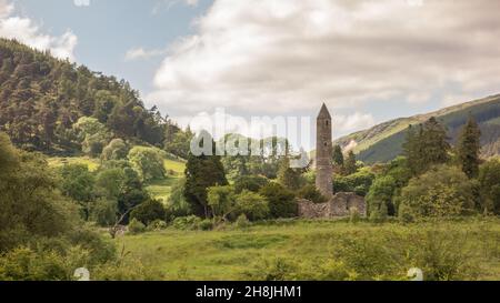 Der frühmittelalterliche Round Tower und der Wald im Glendalough National Park in den Wicklow Mountains, Irland. Stockfoto