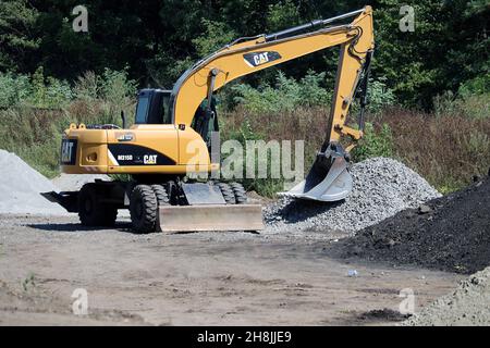 Schpola, Tscherkasy/Ukraine - 08 07 2019: Reparatur der Straße Schpola - Smela. Bagger CAT belädt zerkleinerten Stein. Stockfoto
