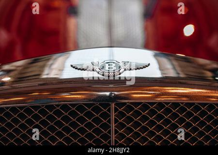 Silbernes, berühmtes Bentley-Logo auf der Vorderseite des roten Bentley Continental-Fahrzeugs. Bentley Motors Limited ist ein britischer Luxusautomatenhersteller Stockfoto