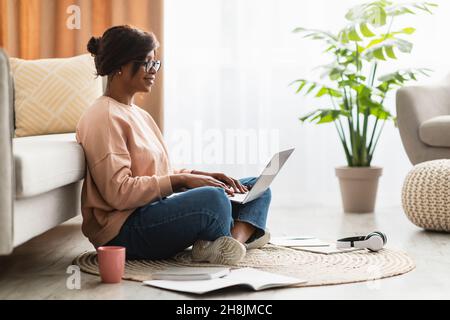 Seitenansicht Der Afroamerikanischen Frau Mit Laptop-Computer Zu Hause Stockfoto