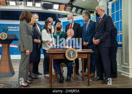 Präsident Joe Biden schüttelt sich die Hände mit Kelly McHugh-Stewart, bevor er ein Gesetz, benannt nach ihrem Vater, S.1095, "Colonel John M. McHugh Tuition Fairness for Survivors Act von 2021, im South Court Auditorium des Eisenhower Executive Office Building des Weißen Hauses in Washington, DCNovember 30, 2021, unterzeichnete. Die von Biden unterzeichneten Gesetze sind S. 796, “Protecting Moms Who Serent Act von 2021, S. 894, “Hire Veteran Health Heroes Act von 2021, S. 1031, “Ein Gesetzentwurf, um den Comptroller General der Vereinigten Staaten zu verlangen, eine Studie über Disparitäten im Zusammenhang mit Rasse und Ethnizität in Bezug auf Certai durchzuführen Stockfoto