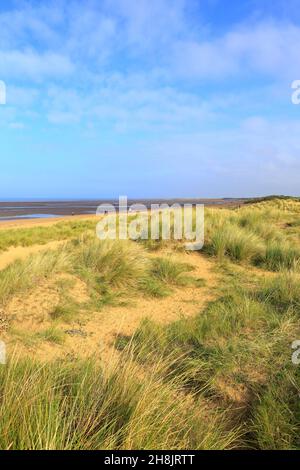 Menschen, die am Old Hunstanton Beach auf dem Peddlers Way Trail und dem Norfolk Coast Path, Norfolk, England, Großbritannien, spazieren gehen. Stockfoto