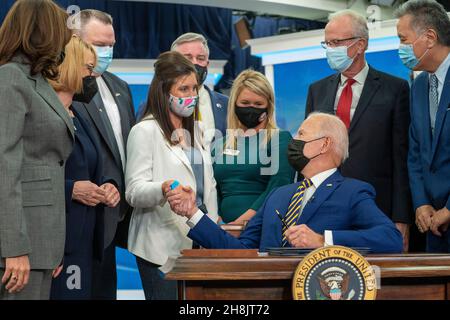 Präsident Joe Biden schüttelt sich die Hände mit Kelly McHugh-Stewart, bevor er ein Gesetz, benannt nach ihrem Vater, S.1095, "Colonel John M. McHugh Tuition Fairness for Survivors Act von 2021, im South Court Auditorium des Eisenhower Executive Office Building des Weißen Hauses in Washington, DCNovember 30, 2021, unterzeichnete. Die von Biden unterzeichneten Gesetze sind S. 796, “Protecting Moms Who Serent Act von 2021, S. 894, “Hire Veteran Health Heroes Act von 2021, S. 1031, “Ein Gesetzentwurf, um den Comptroller General der Vereinigten Staaten zu verlangen, eine Studie über Disparitäten im Zusammenhang mit Rasse und Ethnizität in Bezug auf Certai durchzuführen Stockfoto