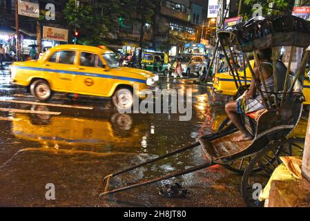 Kolkatas Rickshaw-Abzieher. Die dichte Metropole gehört zu den einzigen Orten in Indien – und zu den wenigen, die auf der Welt noch übrig sind – wo noch immer Flotten von handgezogenen Rikschas auf den Straßen unterwegs sind. Kalkutta, Indien. Stockfoto