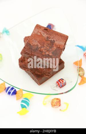 Stapel von Brownies auf Glasplatte mit High-Key-Hintergrund und harten Süßigkeiten Stockfoto